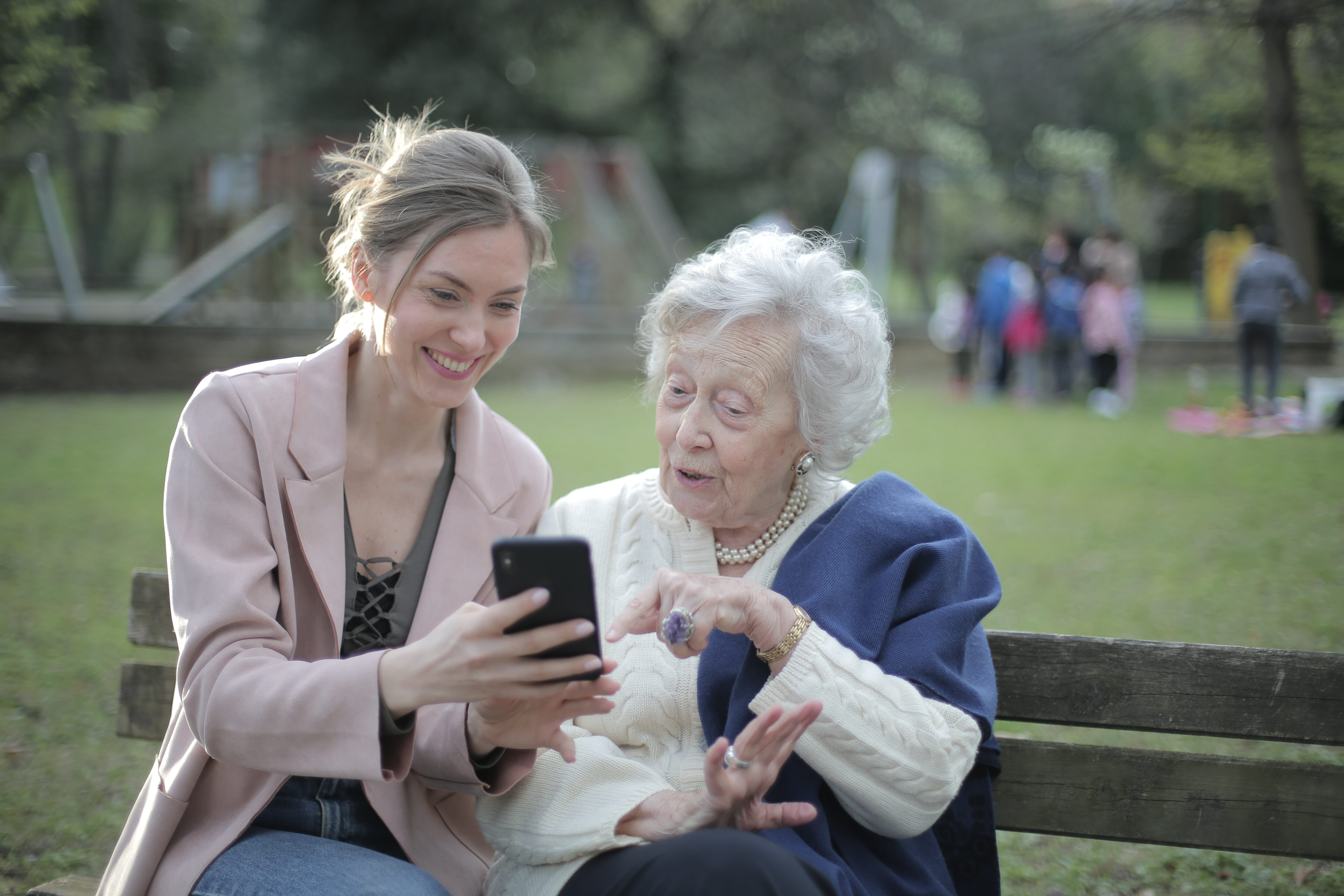 young woman helping an older woman with a phone