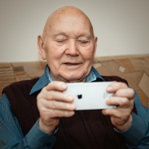 portrait of a stylish older man holding a smartphone