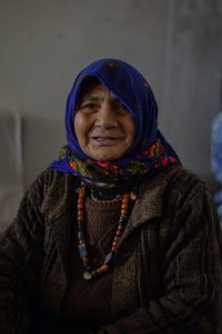 older woman with colourful headscarf and necklaces