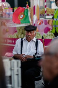 old man with Portuguese flag attached to chair